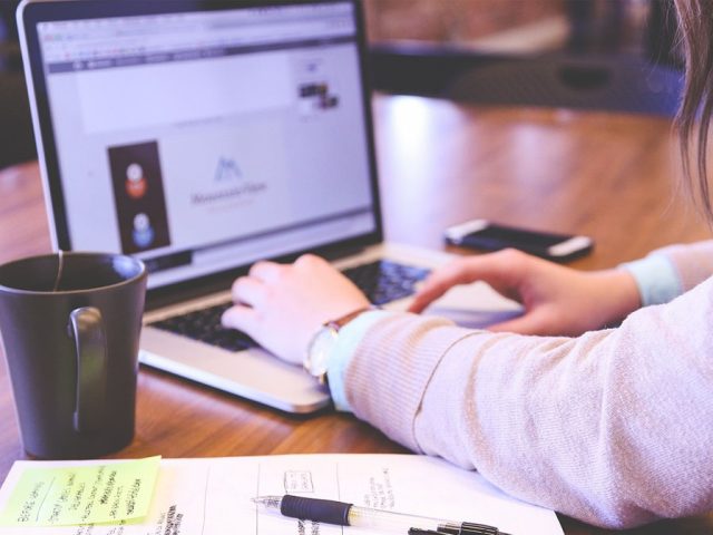 A person working at a desk on a laptop with a cup of coffee and their mobile phone by their side.Image: Pixabay /Startupstockphotos