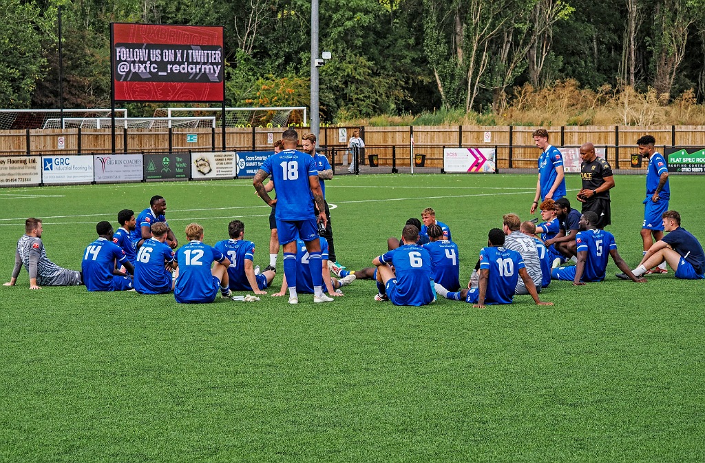 Bedford Town squad sitting in a circle after the game at Uxbridge Town on Saturday 26 July 2025