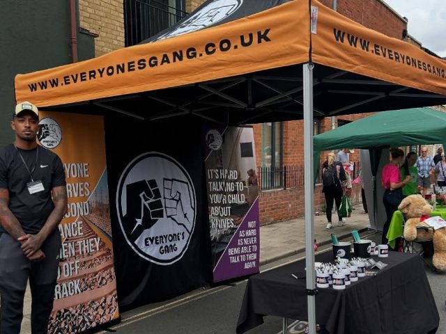 A member of the community interest group, Everyone's Gang at a stall