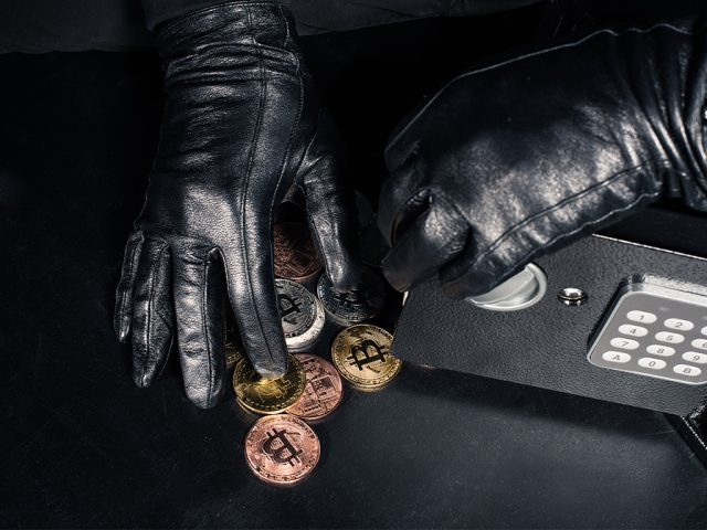 Concept image of thief stealing bitcoin from safe Image LightField Studios shutterstock